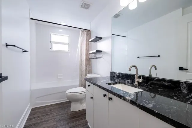 a bathroom with a double vanity sink toilet and shower