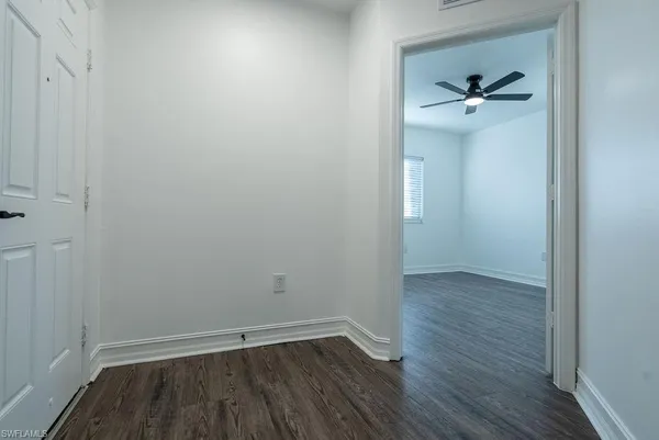 a view of empty room with wooden floor