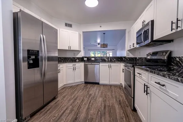 a kitchen with stainless steel appliances granite countertop a stove a sink and a refrigerator