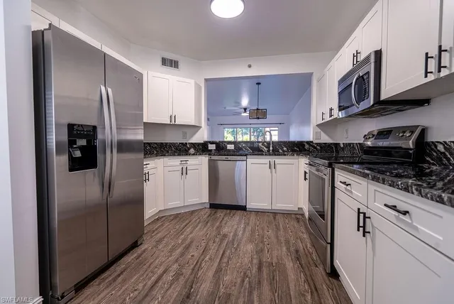 a kitchen with stainless steel appliances granite countertop a stove a sink and a refrigerator