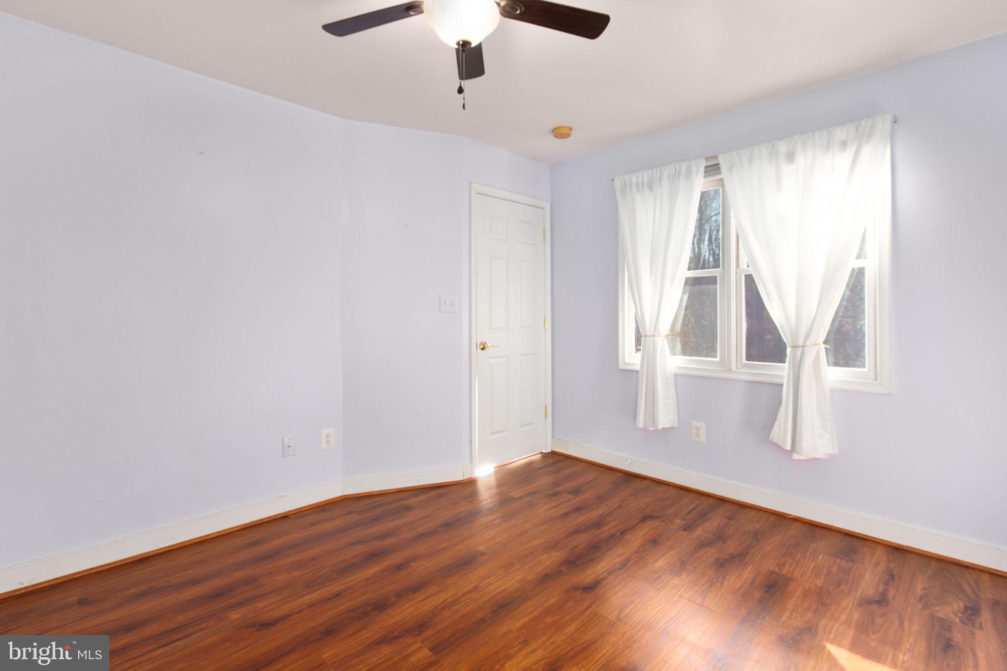 7312 Sugar Hollow Road Orange, VA 22960 - Photo 19 of 47 an empty room with wooden floor chandelier fan and windows