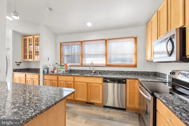 a kitchen with stainless steel appliances granite countertop sink stove and granite counter top