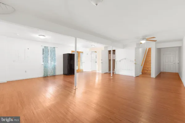 a view of a livingroom with wooden floor and stairs