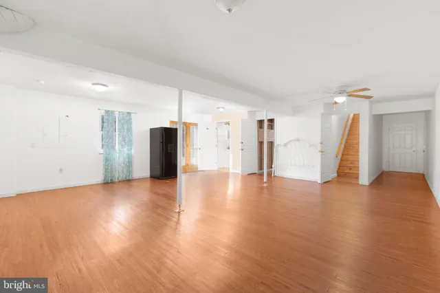 a view of a livingroom with wooden floor and stairs