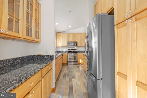 a view of a kitchen with kitchen island a counter top space a sink a refrigerator and a window