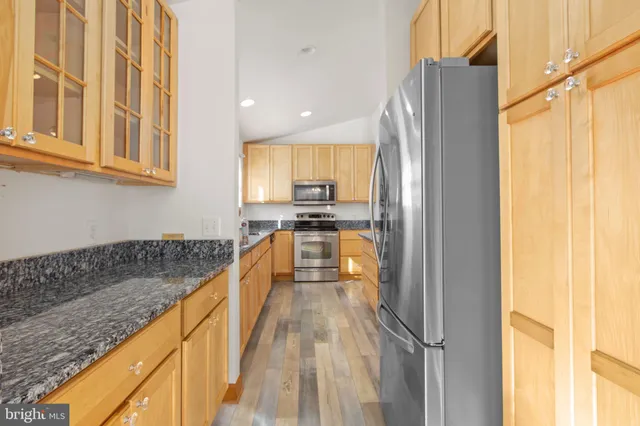 a view of a kitchen with kitchen island a counter top space a sink a refrigerator and a window