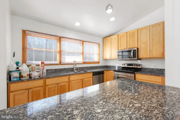 a kitchen with stainless steel appliances granite countertop sink stove top oven and cabinets