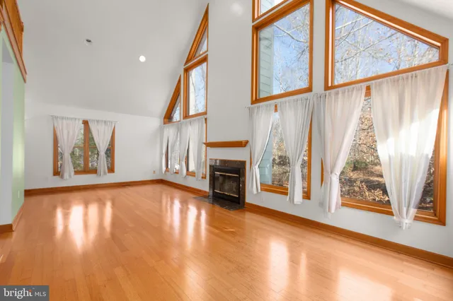a view of an empty room with fireplace and a window
