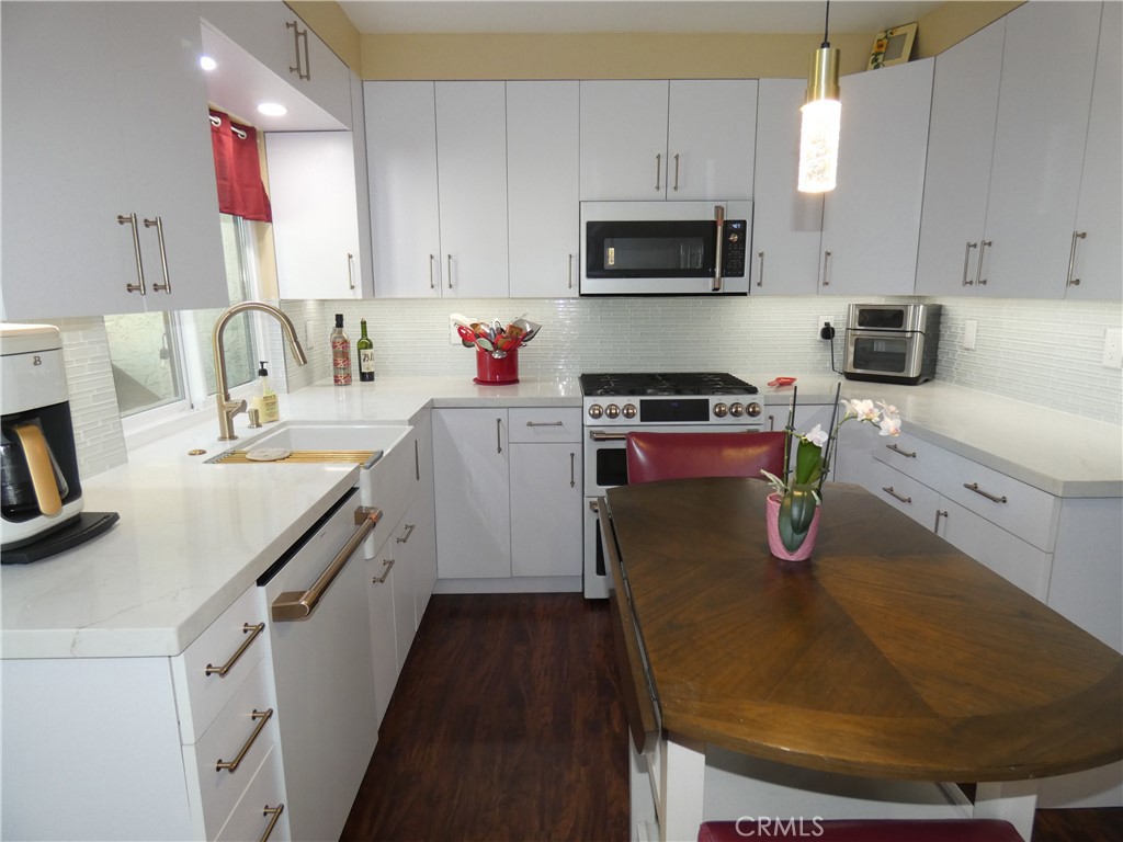 334 West Santa Elena Road Palm Springs, CA 92262 - Photo 5 of 45 a kitchen with kitchen island granite countertop a sink a stove and cabinets