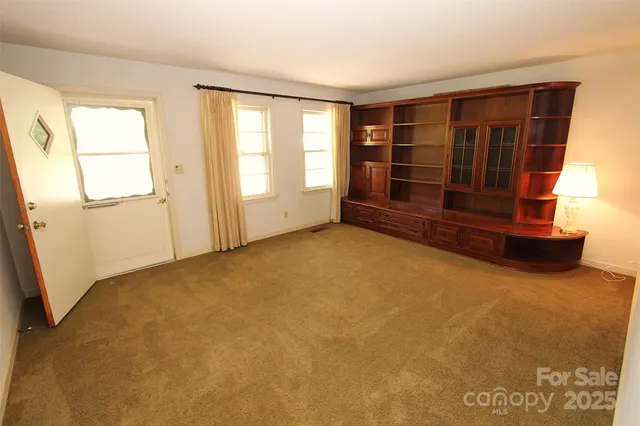 an empty room with a fireplace and window