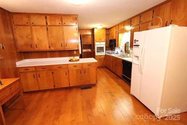 a large kitchen with a large window a counter space and appliances