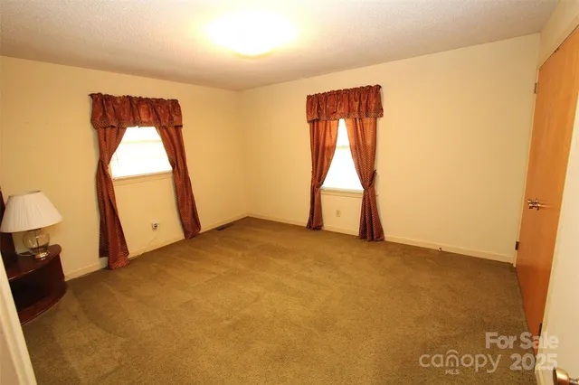a view of empty room with wooden floor and window