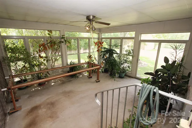 a room with lots of potted plants and wooden floor