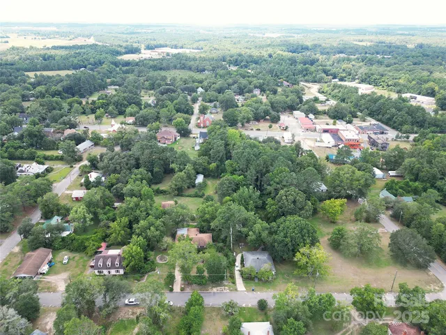 a view of a house with a lush green forest