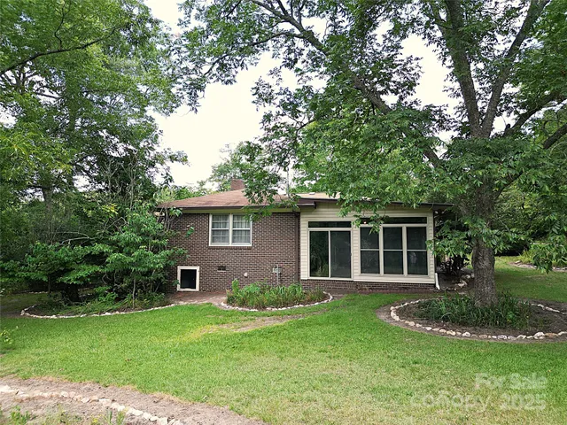 a front view of a house with a yard and trees