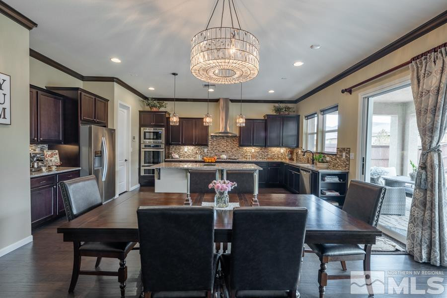 9898 Firefoot Lane Reno, NV 89521 - Photo 10 of 40 a kitchen with stainless steel appliances granite countertop a dining table chairs refrigerator and cabinets