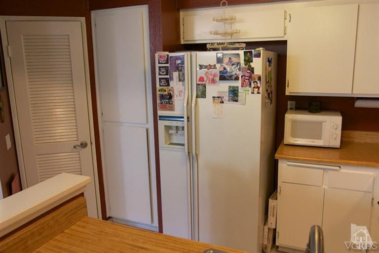 1742 Sinaloa Road, Unit 335 Simi Valley, CA 93065 - Photo 14 of 28 a white refrigerator freezer and a stove sitting inside of a kitchen