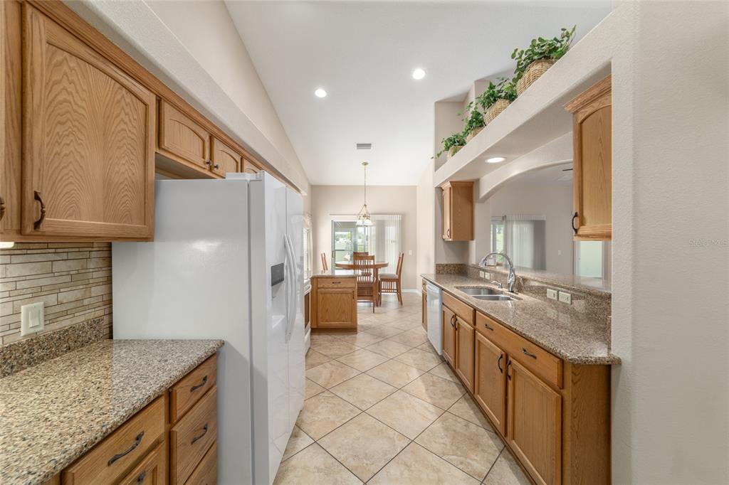 16369 Southwest 14th Avenue Road Ocala, FL 34473 - Photo 16 of 49 a large kitchen with kitchen island granite countertop a large counter top and sink