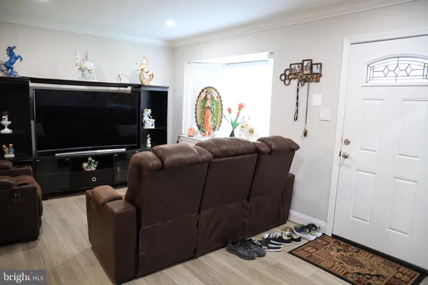 a living room with furniture a flat screen tv and a window