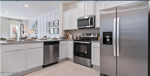 a kitchen with stainless steel appliances granite countertop a refrigerator a stove top oven a sink and dishwasher