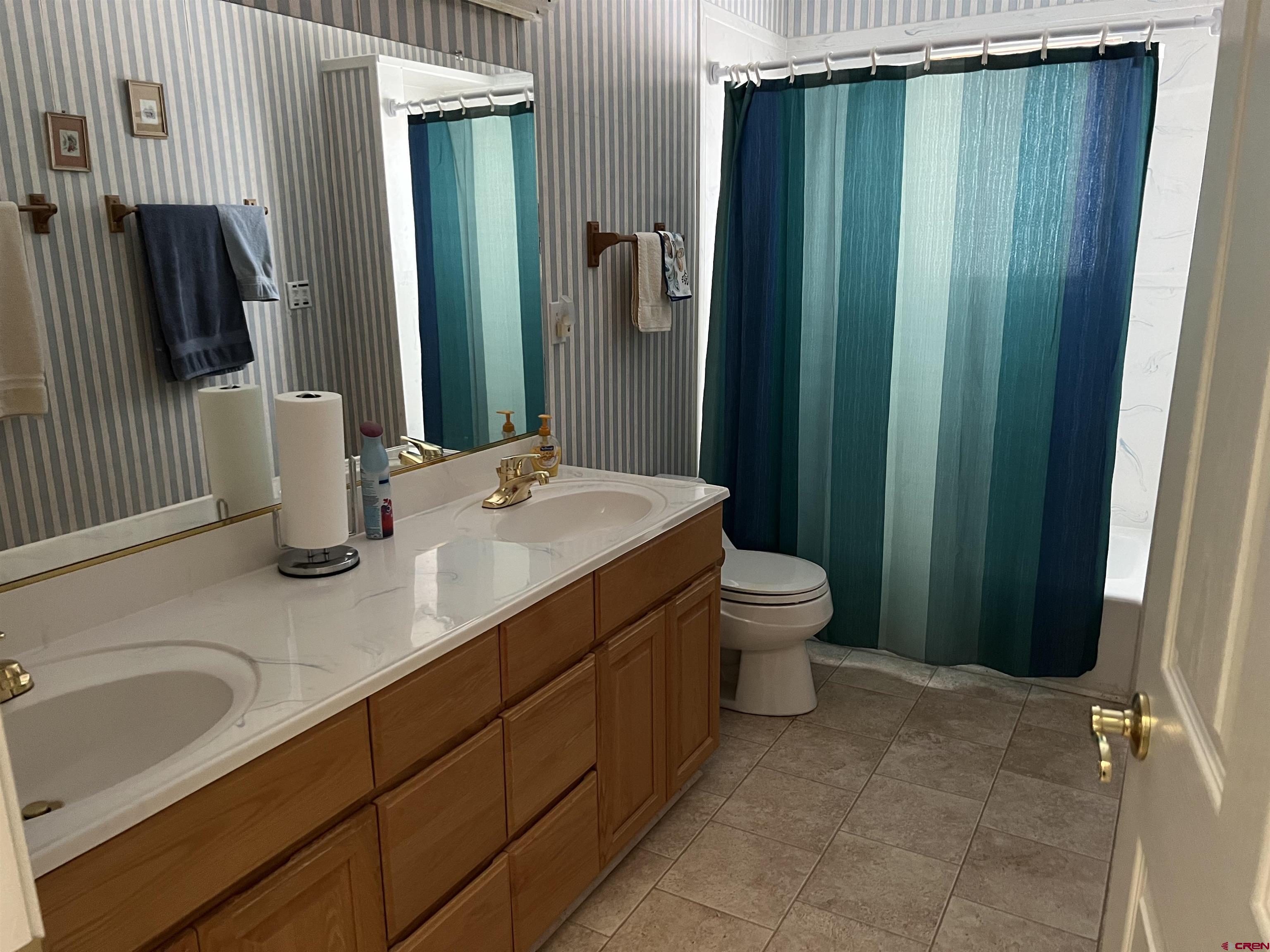 26096 Paintbrush Road Cedaredge, CO 81413 - Photo 17 of 29 a bathroom with a double vanity sink toilet and shower