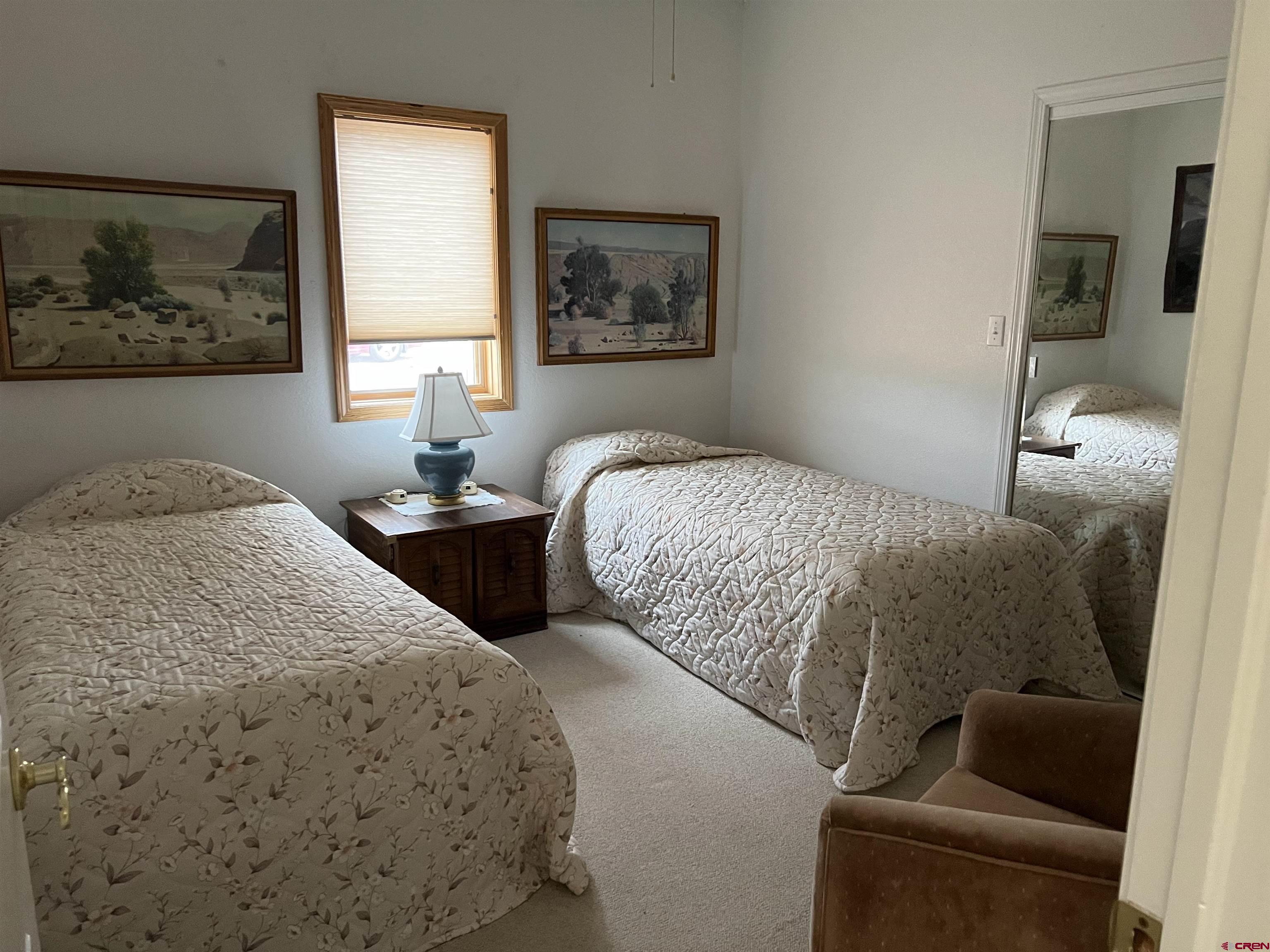 26096 Paintbrush Road Cedaredge, CO 81413 - Photo 23 of 29 a bedroom with two beds and a window