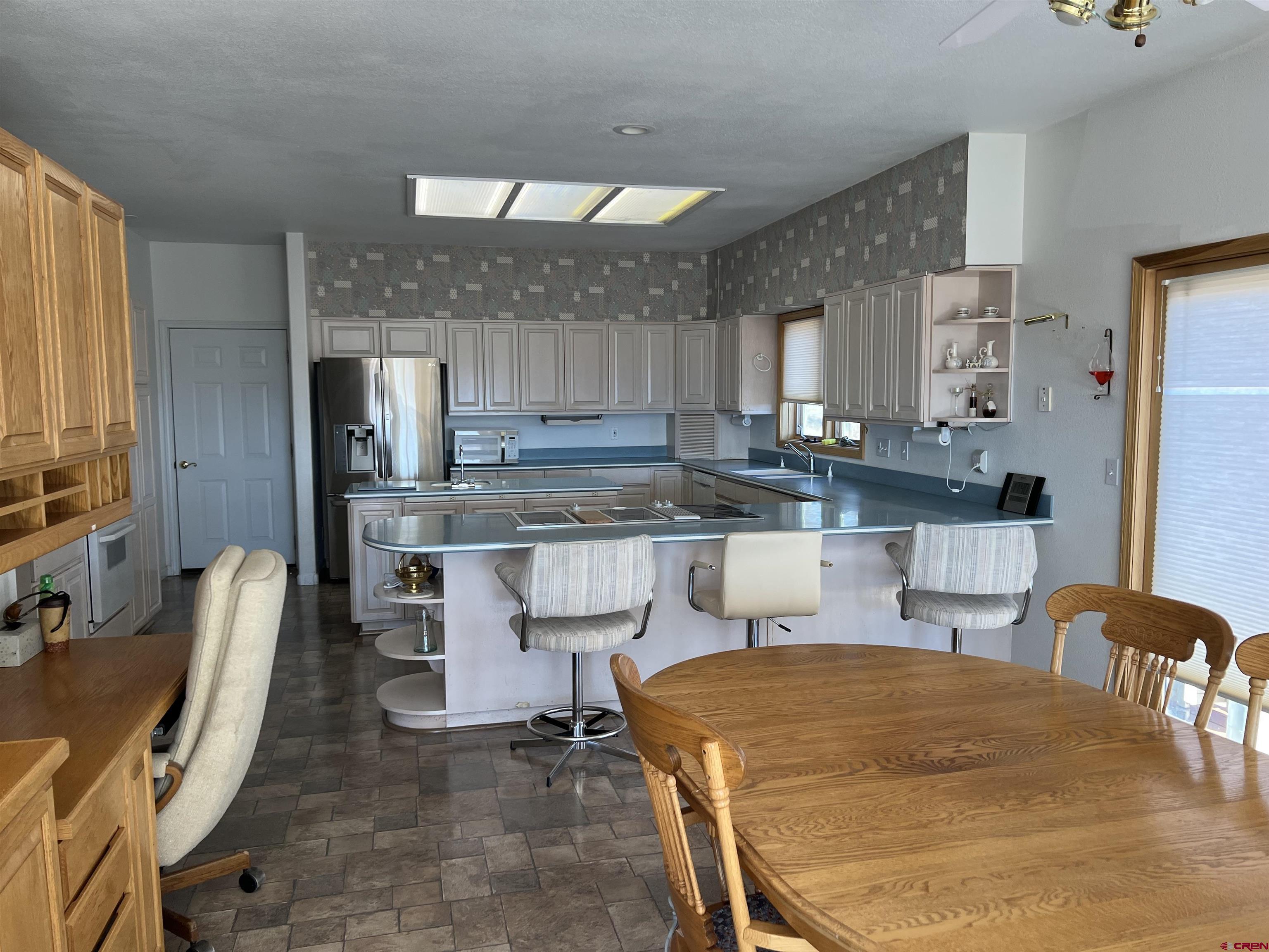 26096 Paintbrush Road Cedaredge, CO 81413 - Photo 6 of 29 a kitchen with stainless steel appliances granite countertop a table chairs and a refrigerator