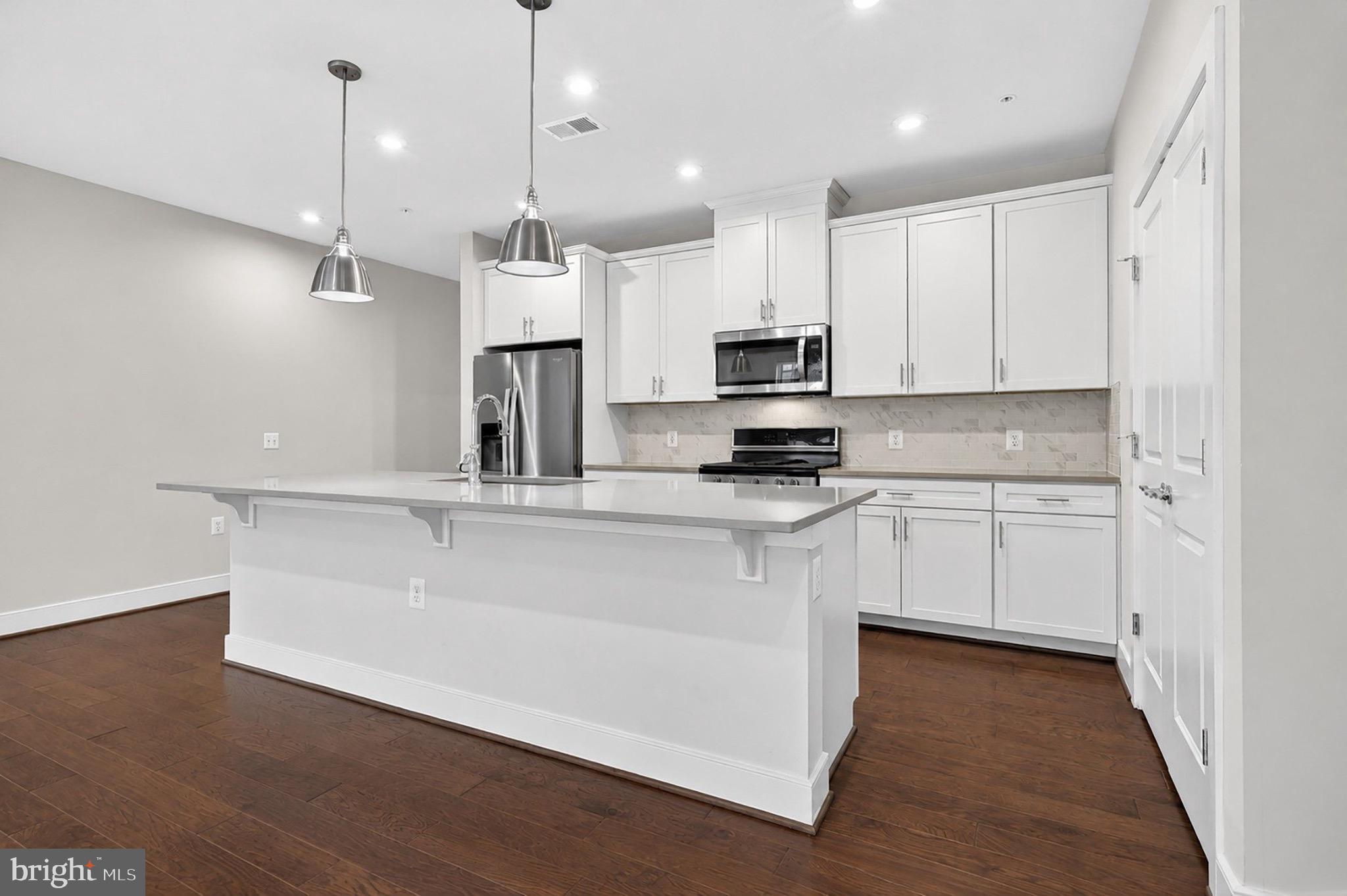 2319 Field Point Road, Unit 102 Herndon, VA 20171 - Photo 8 of 20 a kitchen with kitchen island a sink stainless steel appliances and cabinets