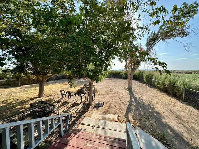 a view of a yard with wooden fence