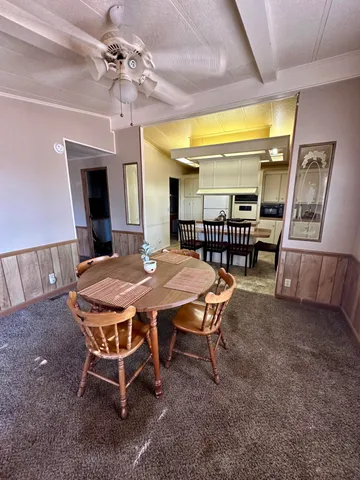 a dining room with a wooden table and chairs
