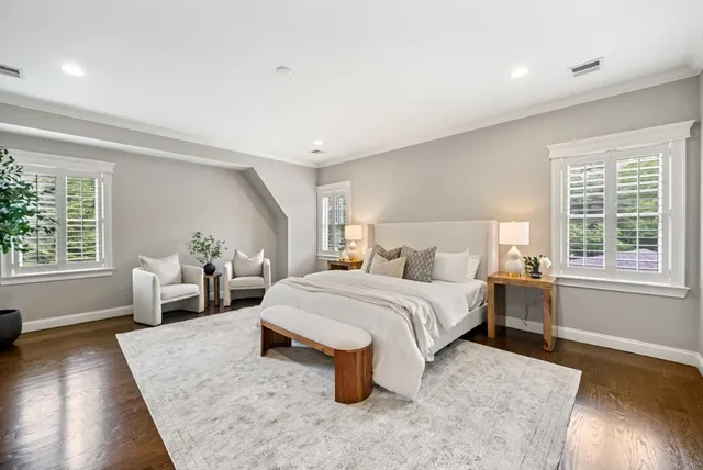 a bedroom with a large bed and wooden floor