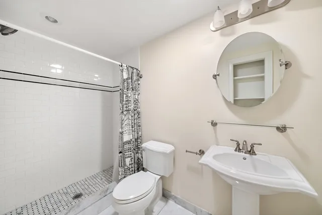 a bathroom with a sink a toilet and shower