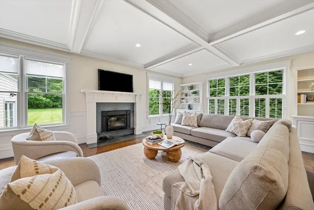 a living room with furniture fireplace and a large window