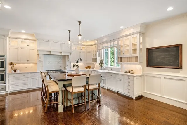 a kitchen with stainless steel appliances kitchen island granite countertop a stove a sink and a microwave