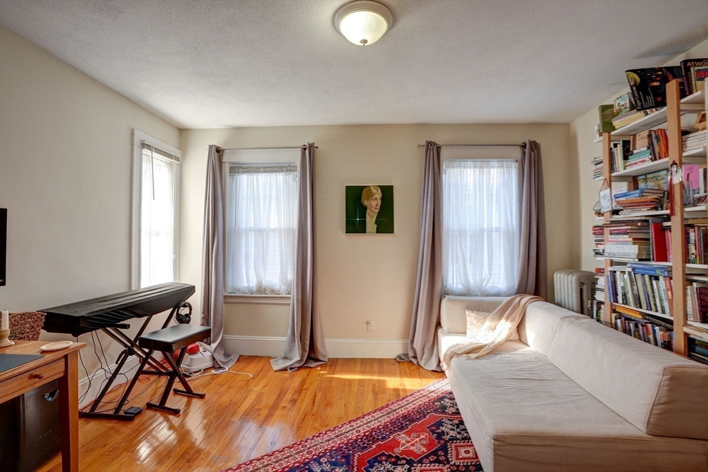 77 2nd Street, Unit 2 Medford, MA 02155 - Photo 14 of 18 a bedroom with furniture and a book shelf