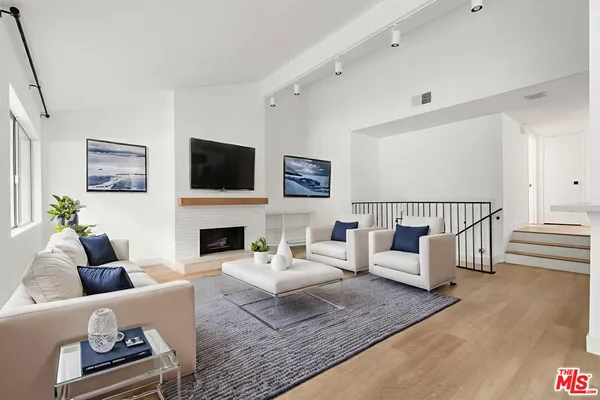 a living room with furniture a fireplace and a flat screen tv