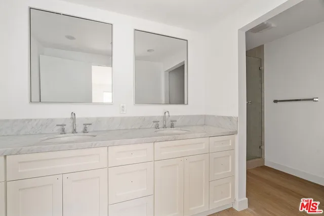 a bathroom with a granite countertop sink double and mirror