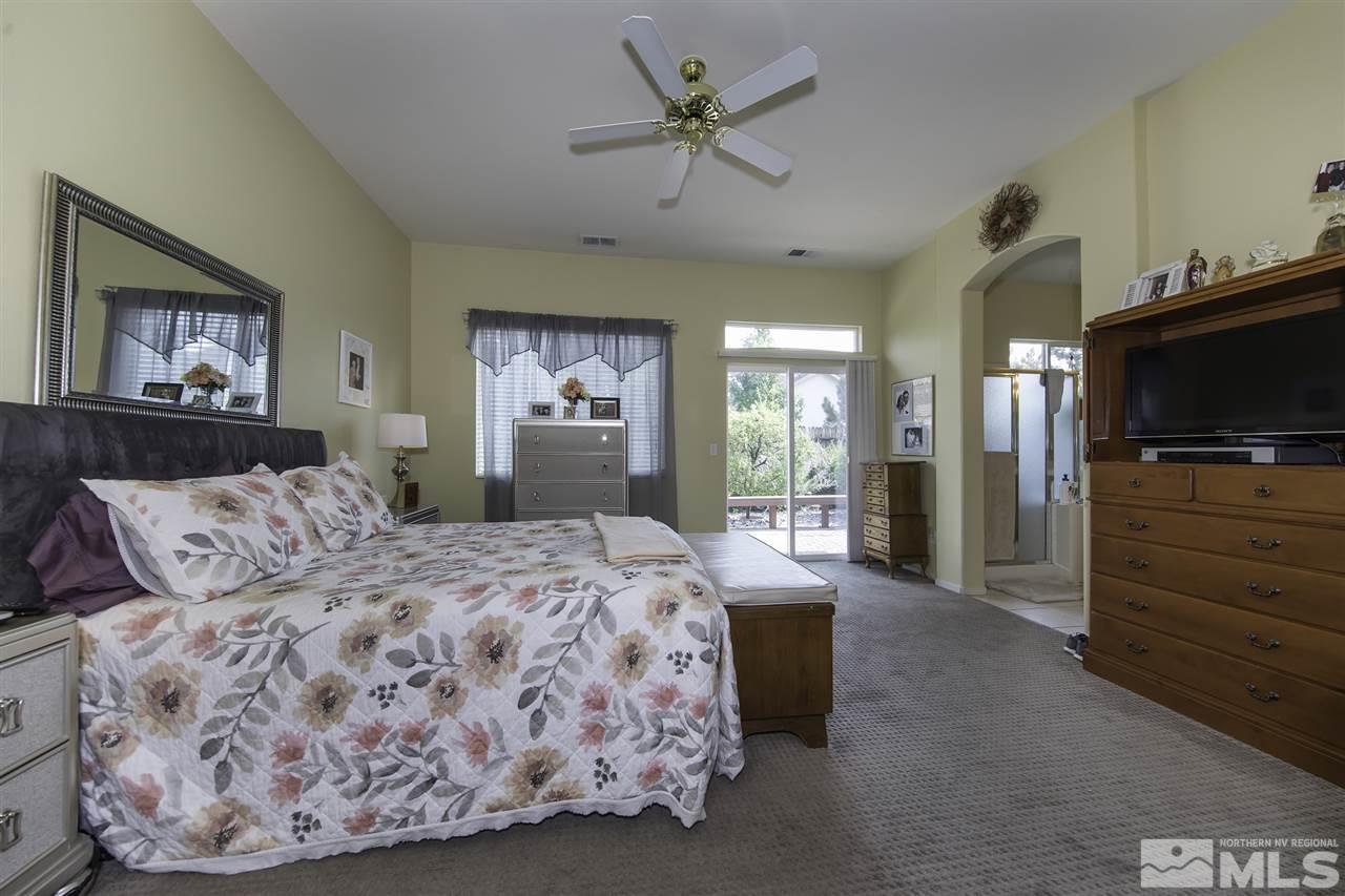 1417 Wild Wolf Way Reno, NV 89521 - Photo 11 of 25 a spacious bedroom with a bed and a flat screen tv