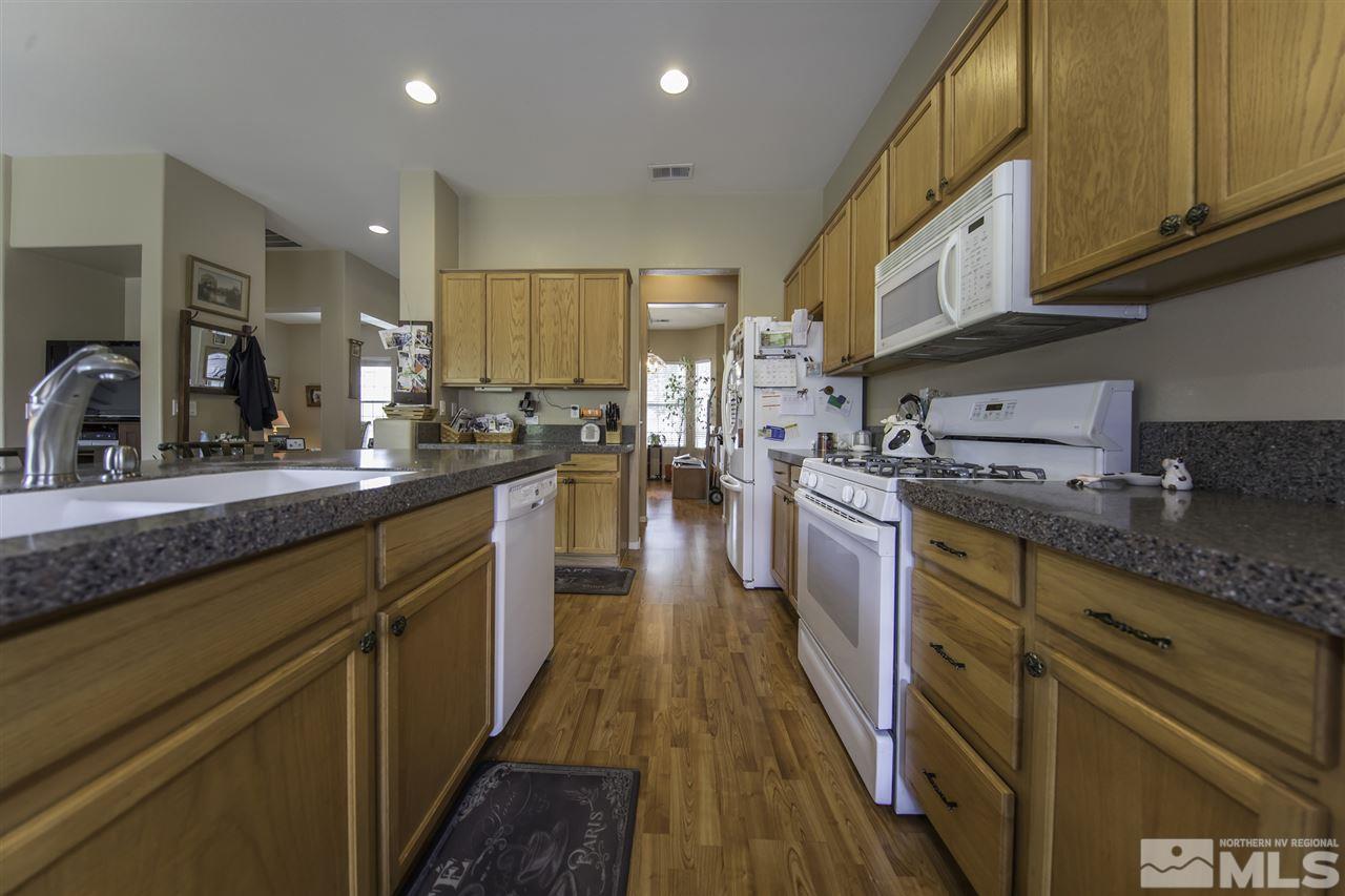 1417 Wild Wolf Way Reno, NV 89521 - Photo 8 of 25 a kitchen with granite countertop a sink a counter top space stainless steel appliances and cabinets