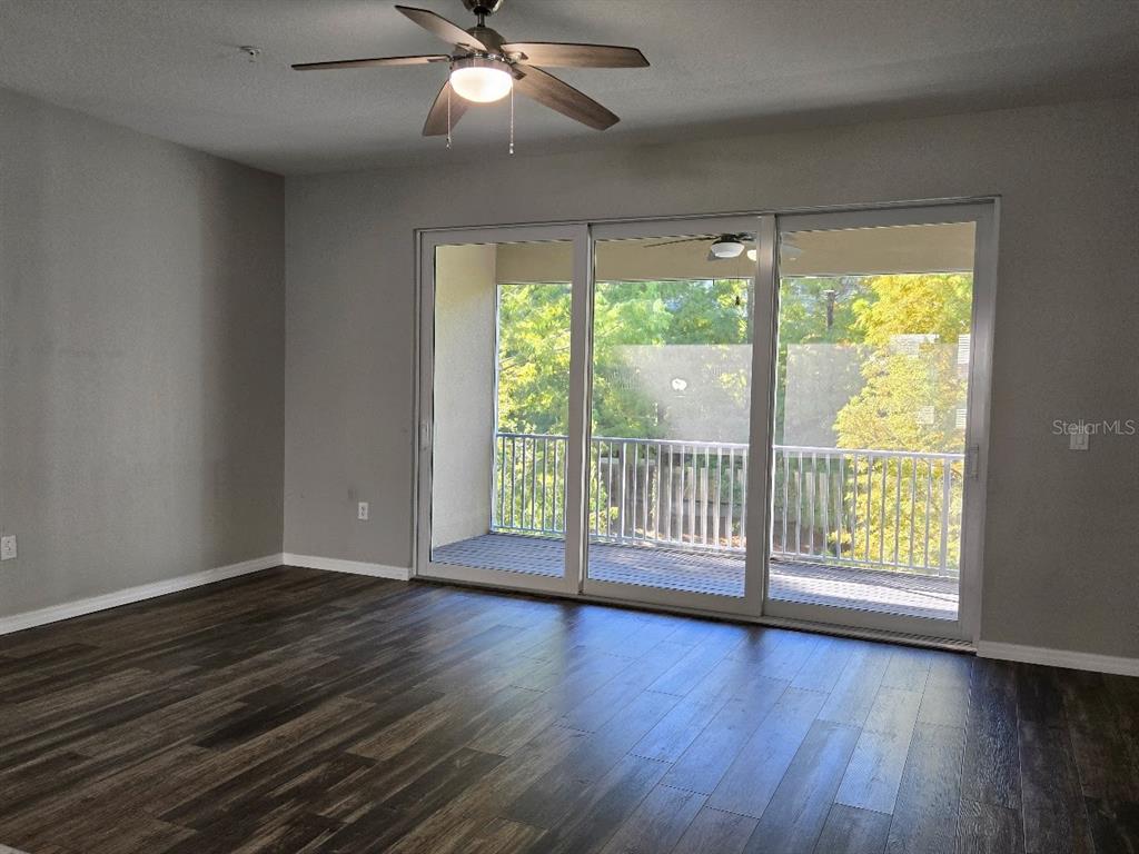 807 Callista Cay Loop Tarpon Springs, FL 34689 - Photo 13 of 32 a view of an empty room with wooden floor and a window