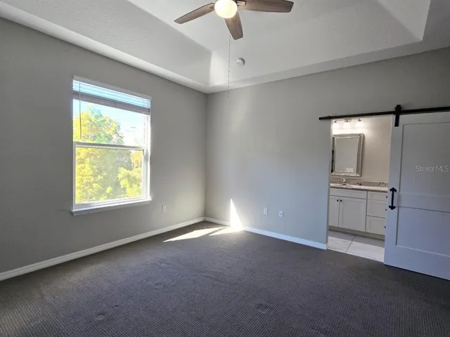 an empty room with a window and a ceiling fan