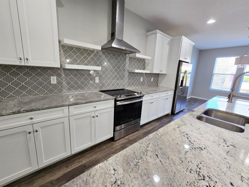 807 Callista Cay Loop Tarpon Springs, FL 34689 - Photo 5 of 32 a kitchen with granite countertop a sink a stove and refrigerator