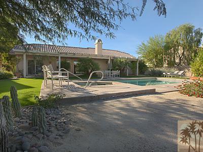 5 White Sun Way Rancho Mirage, CA 92270 - Photo 22 of 24 a view of a patio with table and chairs with wooden fence