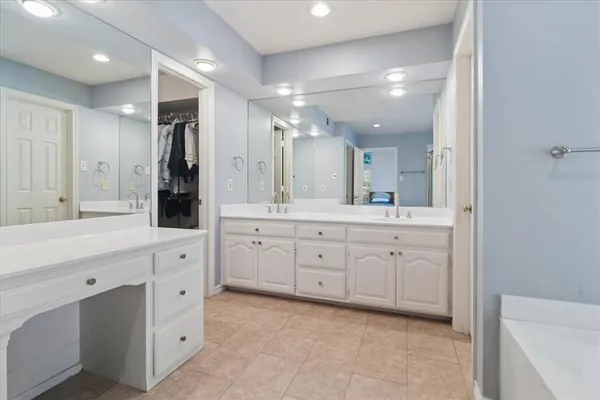 a spacious bathroom with a granite countertop sink mirror and shower