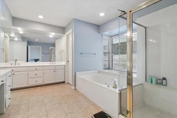 a bathroom with a tub shower and sink