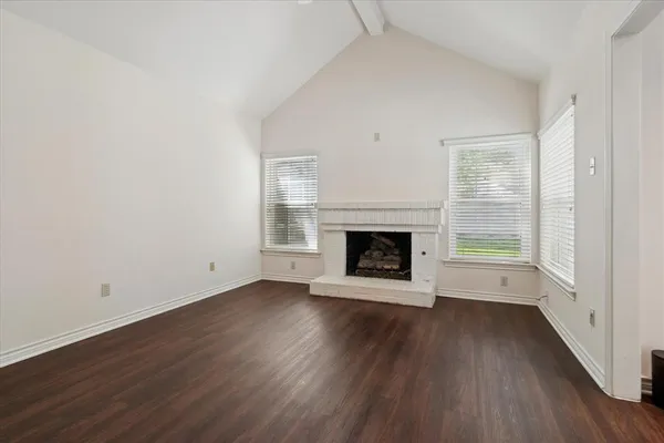 a view of empty room with wooden floor and fireplace