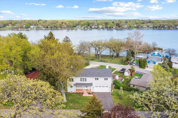 an aerial view of residential houses with outdoor space and lake view