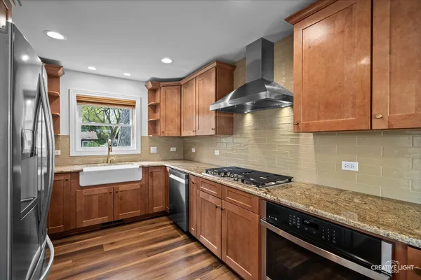 a kitchen with stainless steel appliances granite countertop a stove a sink and a microwave