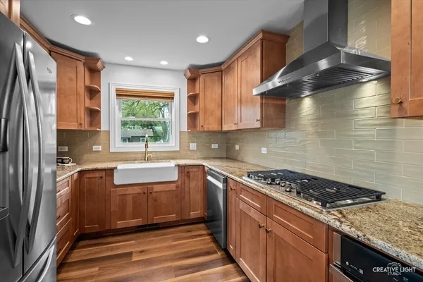 a kitchen with granite countertop a sink stainless steel appliances and cabinets