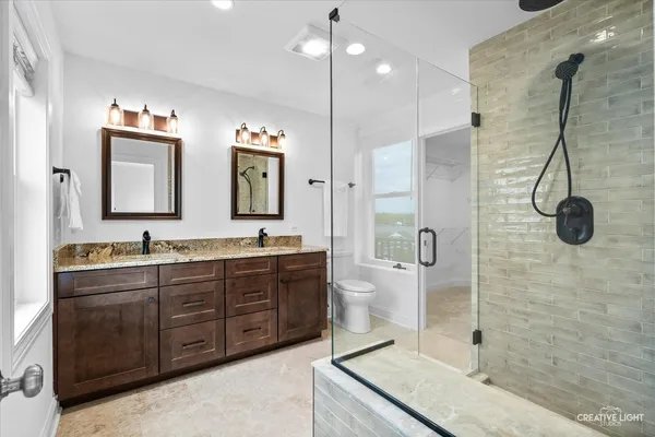 a bathroom with a granite countertop sink mirror and shower